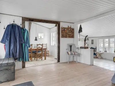 a living room with a door open to a dining room at Holiday Home Sharanya - 500m from the sea by Interhome in Blokhus