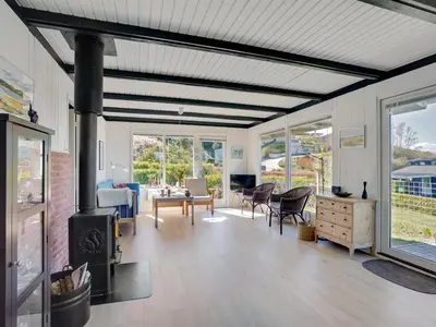 a living room with a fireplace and a table and chairs at Holiday Home Vasilij - 300m to the fjord by Interhome in Farsø