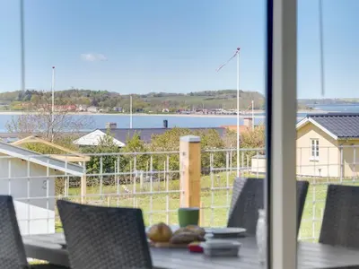 a table and chairs with a view of the water at Holiday Home Vasilij - 300m to the fjord by Interhome in Farsø