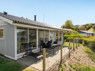 a screened in porch of a house with chairs at Holiday Home Vasilij - 300m to the fjord by Interhome in Farsø