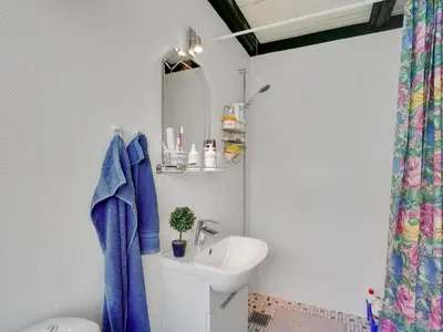 a bathroom with a sink and a toilet with a blue towel at Holiday Home Vasilij - 300m to the fjord by Interhome in Farsø