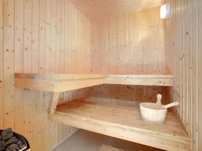 a wooden sauna with a bucket in it at Holiday Home Grimar - 600m from the sea by Interhome in Torsted