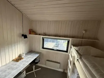 a small room with a desk and a bed at Holiday Home Glenda - 3km from the sea by Interhome in Saltum