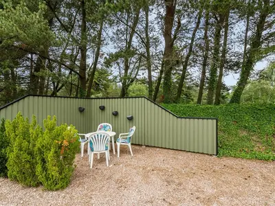 a patio with a table and chairs in a garden at Holiday Home Glenda - 3km from the sea by Interhome in Saltum
