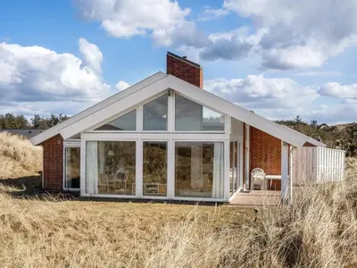 a house with a conservatory on top of a field at Holiday Home Ritha - 350m from the sea by Interhome in Saltum