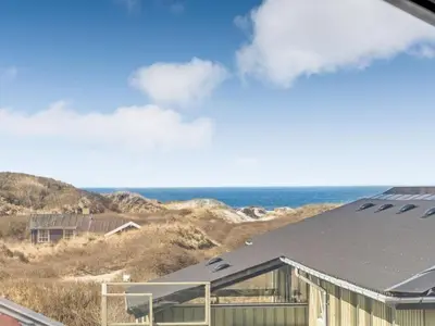 a building on the beach with the ocean in the background at Holiday Home Ritha - 350m from the sea by Interhome in Saltum