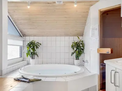 a bathroom with a tub and two potted plants at Holiday Home Ritha - 350m from the sea by Interhome in Saltum