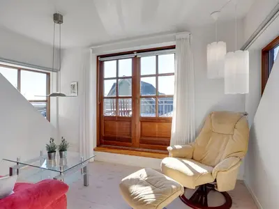 a living room with a chair and a glass table at Holiday Home Iarund - 500m to the fjord by Interhome in Løgstør