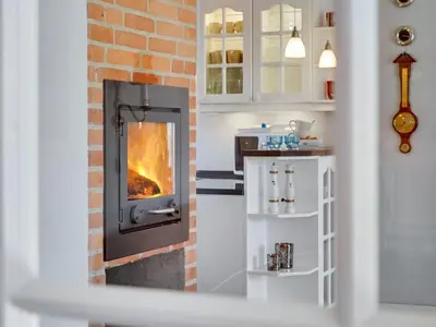 a fireplace in a kitchen with a brick wall at Holiday Home Iarund - 500m to the fjord by Interhome in Løgstør