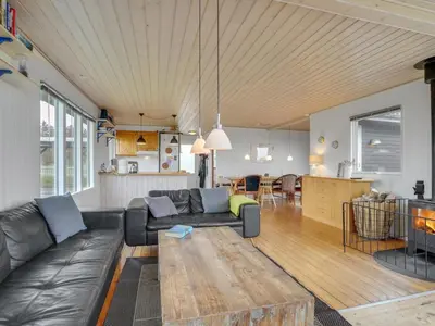 a living room with a leather couch and a table at Holiday Home Awer - 300m to the fjord by Interhome in Struer