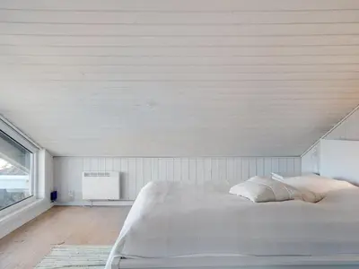 a bedroom with a white bed and a window at Holiday Home Rauli - 50m from the sea by Interhome in Saltum