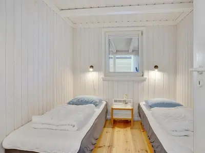 two beds in a white room with a window at Holiday Home Rauli - 50m from the sea by Interhome in Saltum