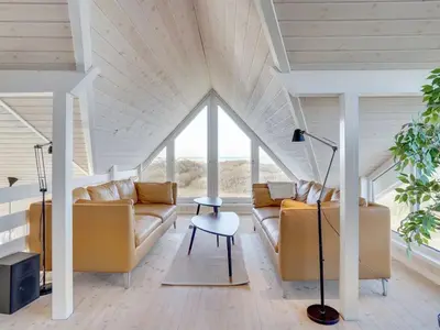 a living room with two couches and a table at Holiday Home Rauli - 50m from the sea by Interhome in Saltum