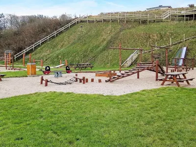 a playground with wooden benches and a slide at 12 person holiday home in Lemvig-By Traum in Lemvig