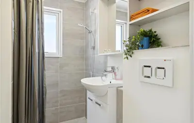 a white bathroom with a sink and a shower at Awesome Apartment In Blokhus With Wifi in Blokhus