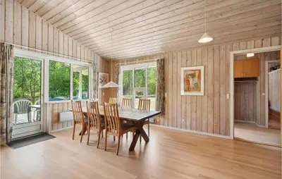 a dining room with a wooden table and chairs at 3 Bedroom Awesome Home In Højslev in Højslev