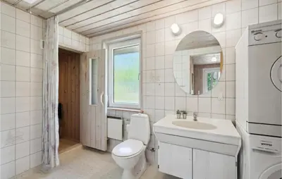 a bathroom with a toilet and a sink and a mirror at 3 Bedroom Awesome Home In Højslev in Højslev