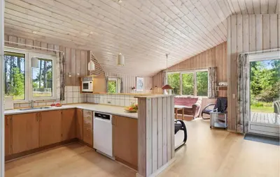 a kitchen with wooden walls and wooden floors and windows at 3 Bedroom Awesome Home In Højslev in Højslev