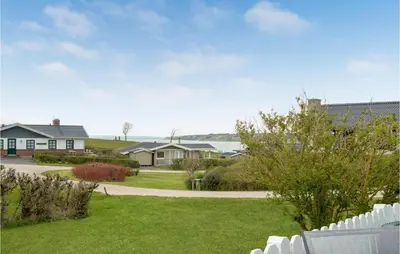 a house with a white fence in a yard at 2 Bedroom Cozy Home In Lemvig in Lemvig