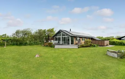 a house in the middle of a grassy yard at Stunning Home In Vestervig With Sauna in Vestervig