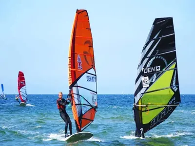 two people are windsurfing in the ocean with sailboards at 6 person holiday home in Løgstør-By Traum in Løgstør