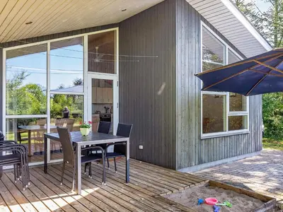 a patio with a table and chairs and an umbrella at 6 person holiday home in Løgstør-By Traum in Løgstør