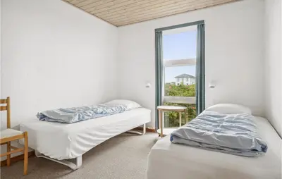 two beds in a room with a window at 4 Bedroom Stunning Home In Thisted in Thisted